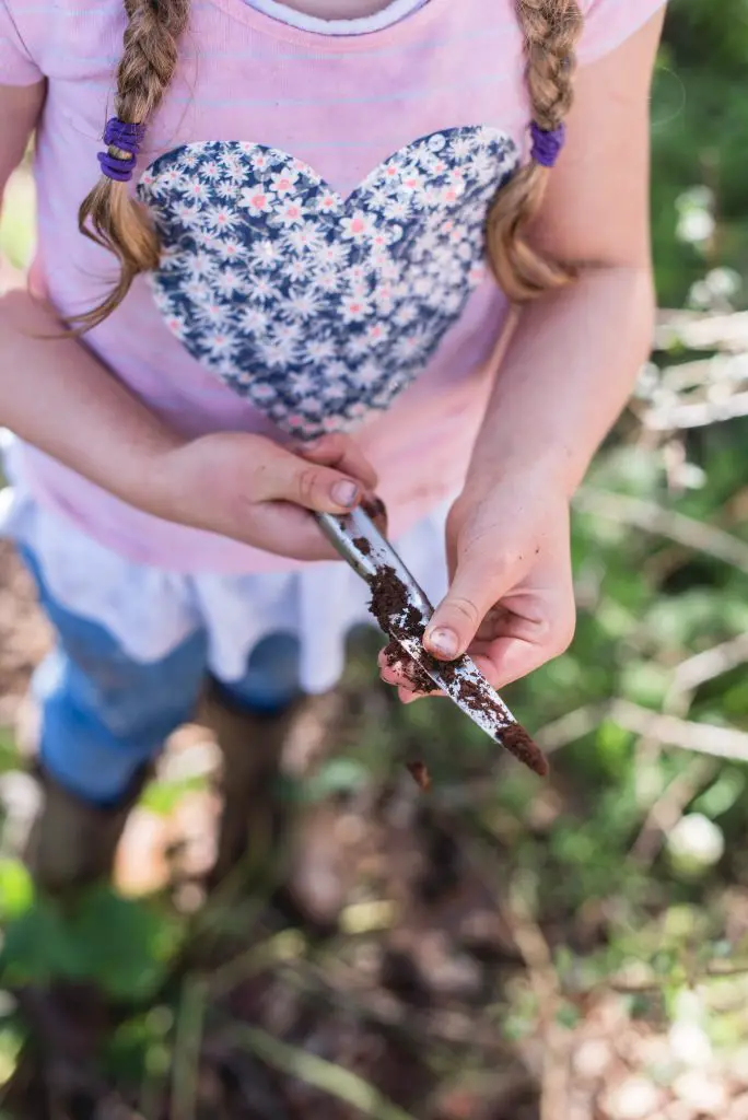 Girl holding garden knife in the garden
