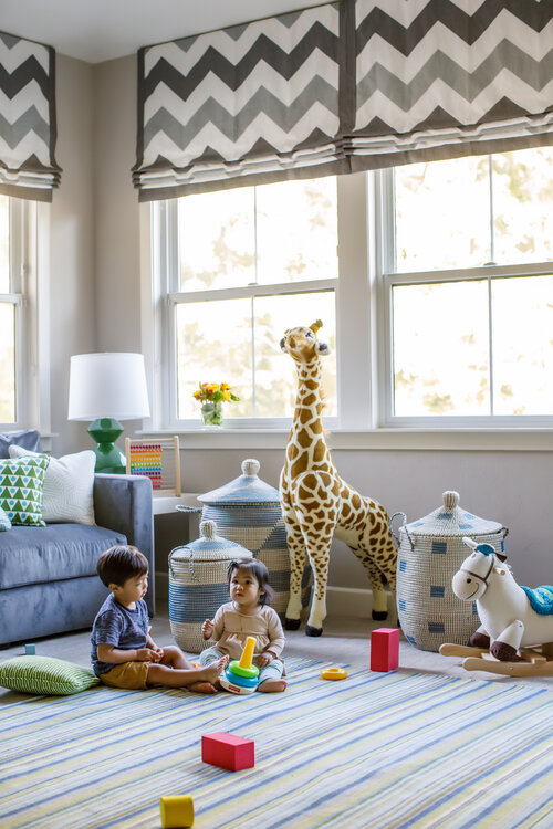 Children's room with toddlers, couch and toys