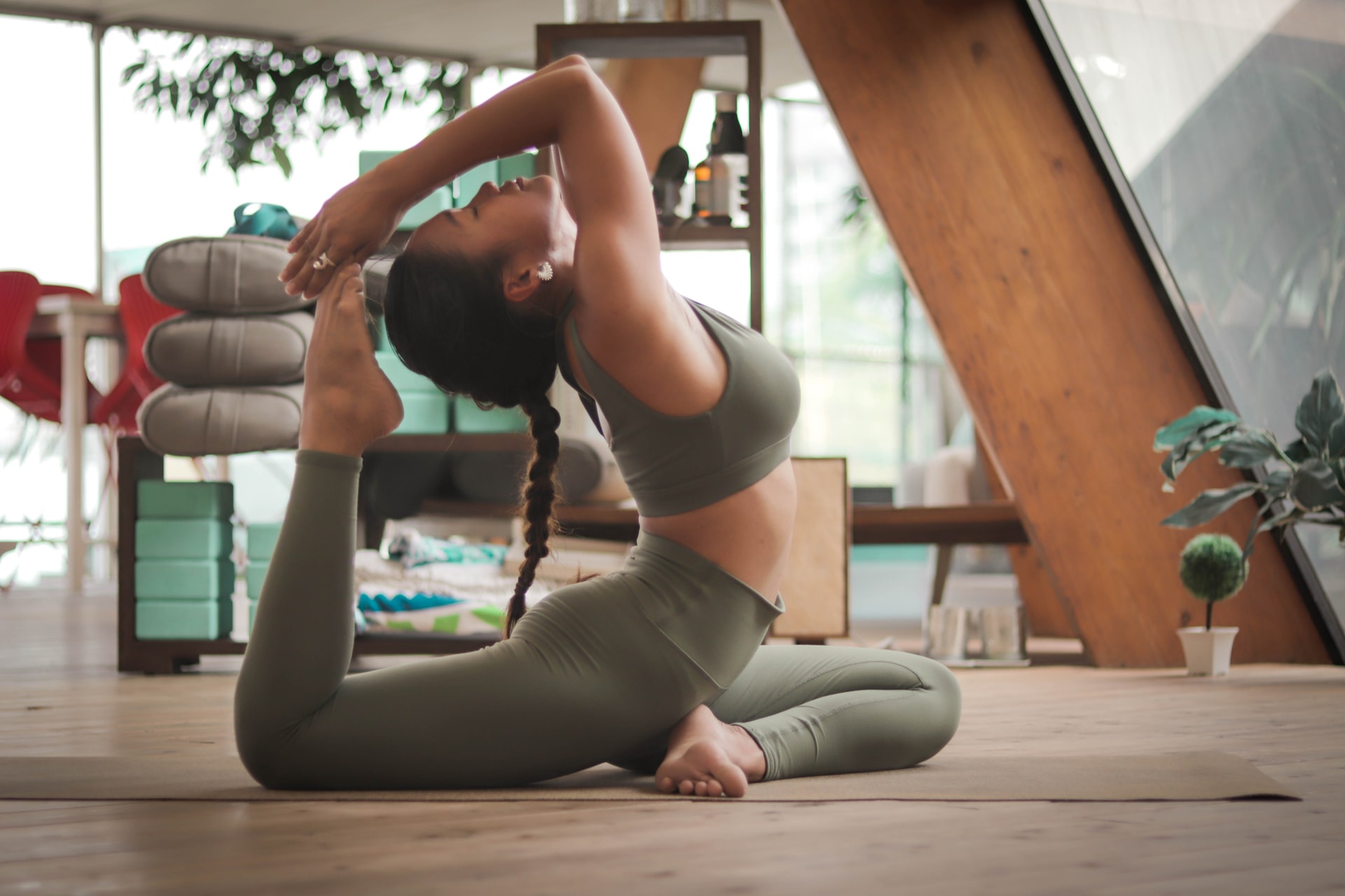 Woman practicing yoga in advanced yoga pose in home gym