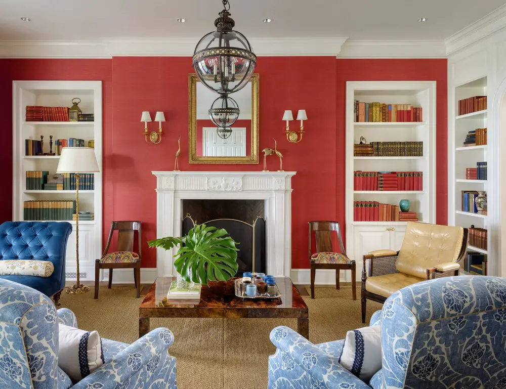 Living room with red wall, blue armchairs and a firework