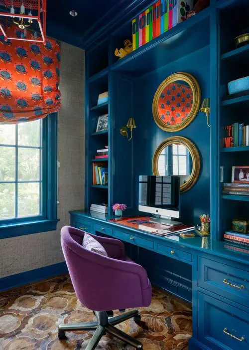 Living room with red wall, blue armchairs and a firework