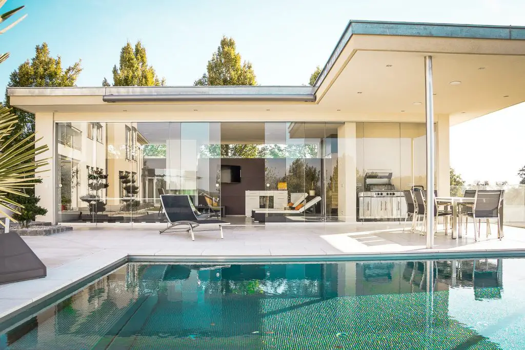 House with a glass wall and a pool