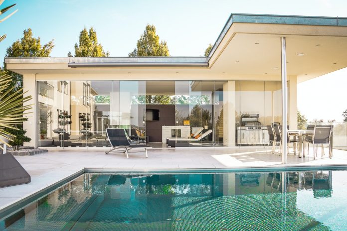 House with a glass wall and a pool