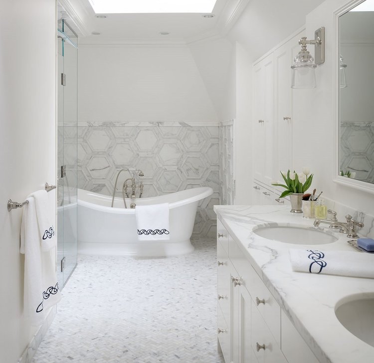 Bathroom with a tub, sink, and towels