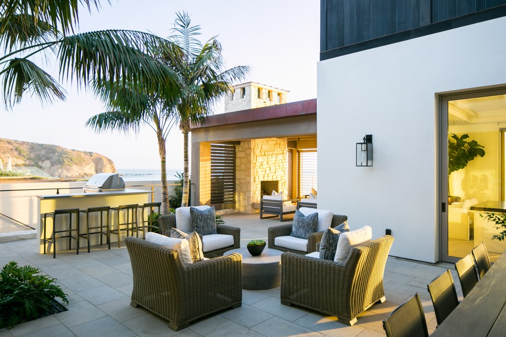 Yard with armchairs, table and palm trees