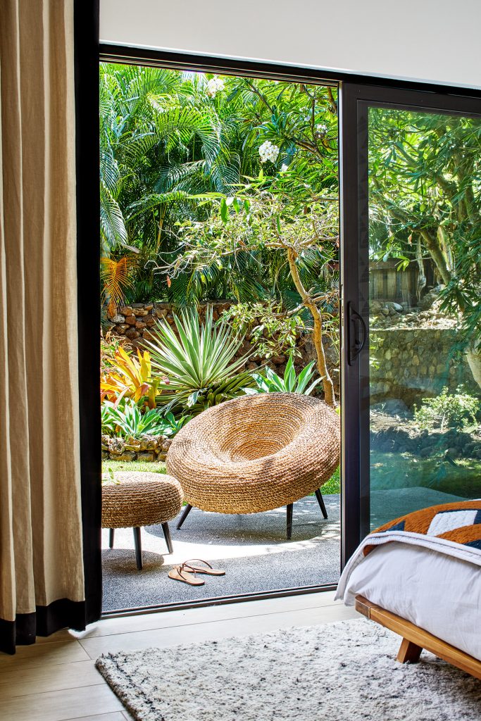 A view from bedroom to porch with tropical plants