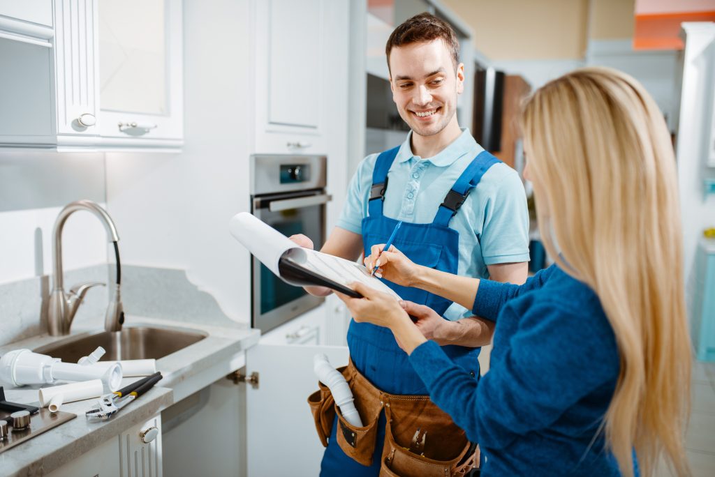 A plumber and a woman in a kitchen