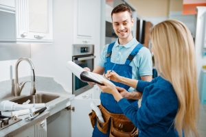 A plumber and a woman in a kitchen
