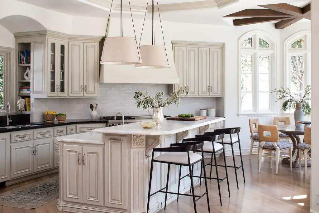 Beige designed kitchen with island and dark bar chairs