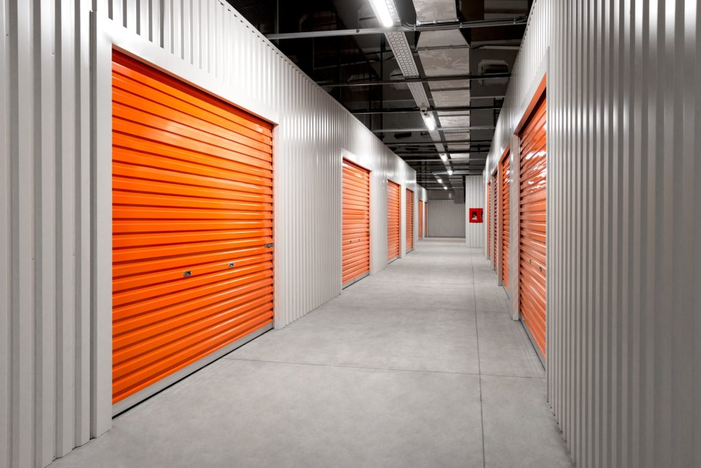 A hall with storages with orange doors and gray walls