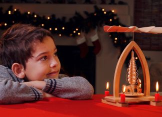 A,Young,Boy,Watches,In,Wonder,As,A,Christmas,Candle
