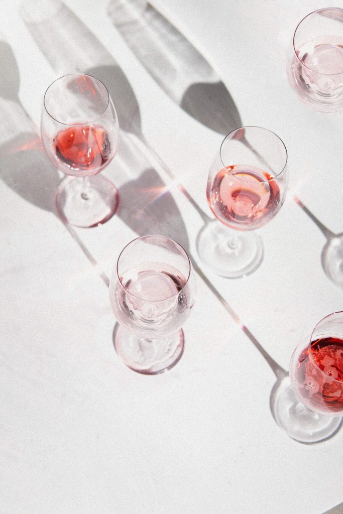 Glasses of wine on the white surface