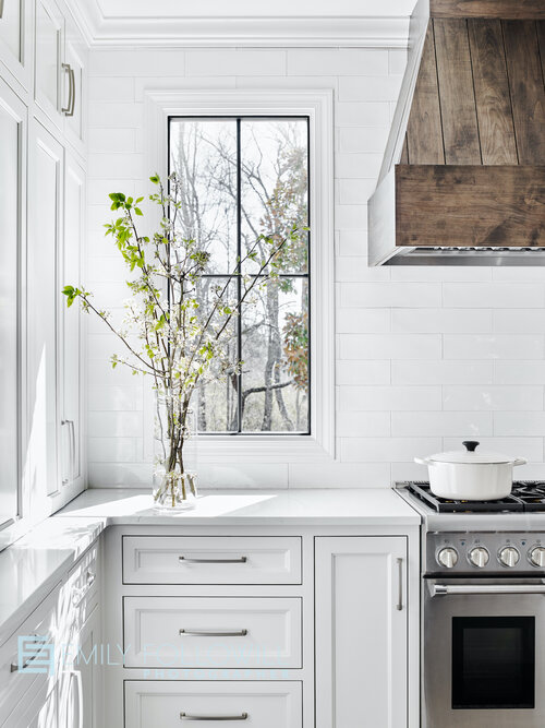 Kitchen cabinet with a vase of flowers and an oven