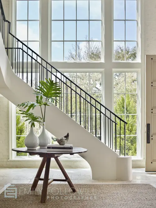 Hallway with stairs, table and flowers in the vase