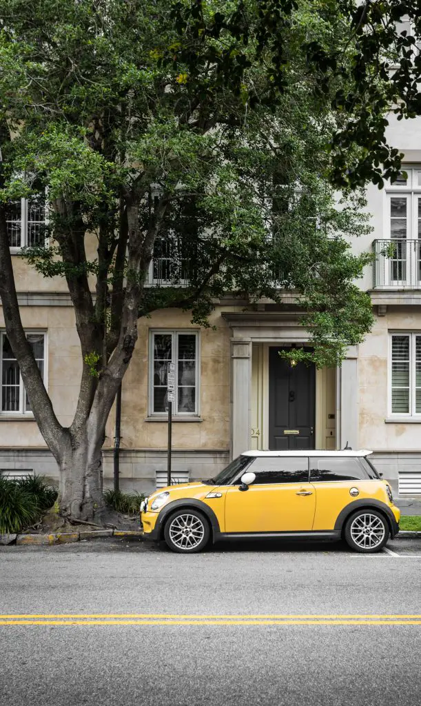 Yellow mini cooper in front of the building