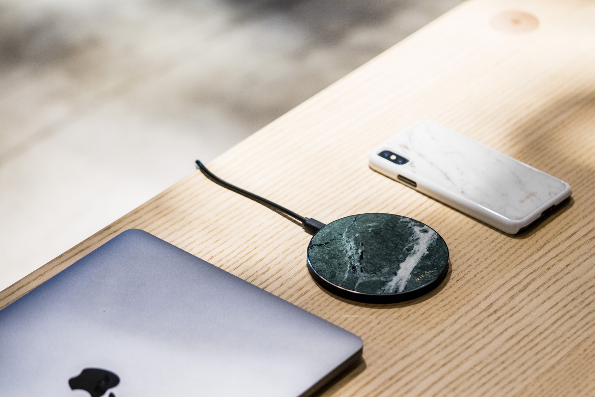 Wireless charger, mobile and a laptop on a table