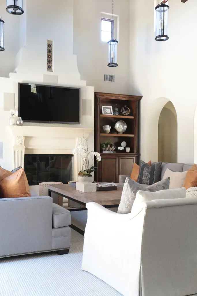 Living room with sofas, armchairs, table and flat TV on the wall