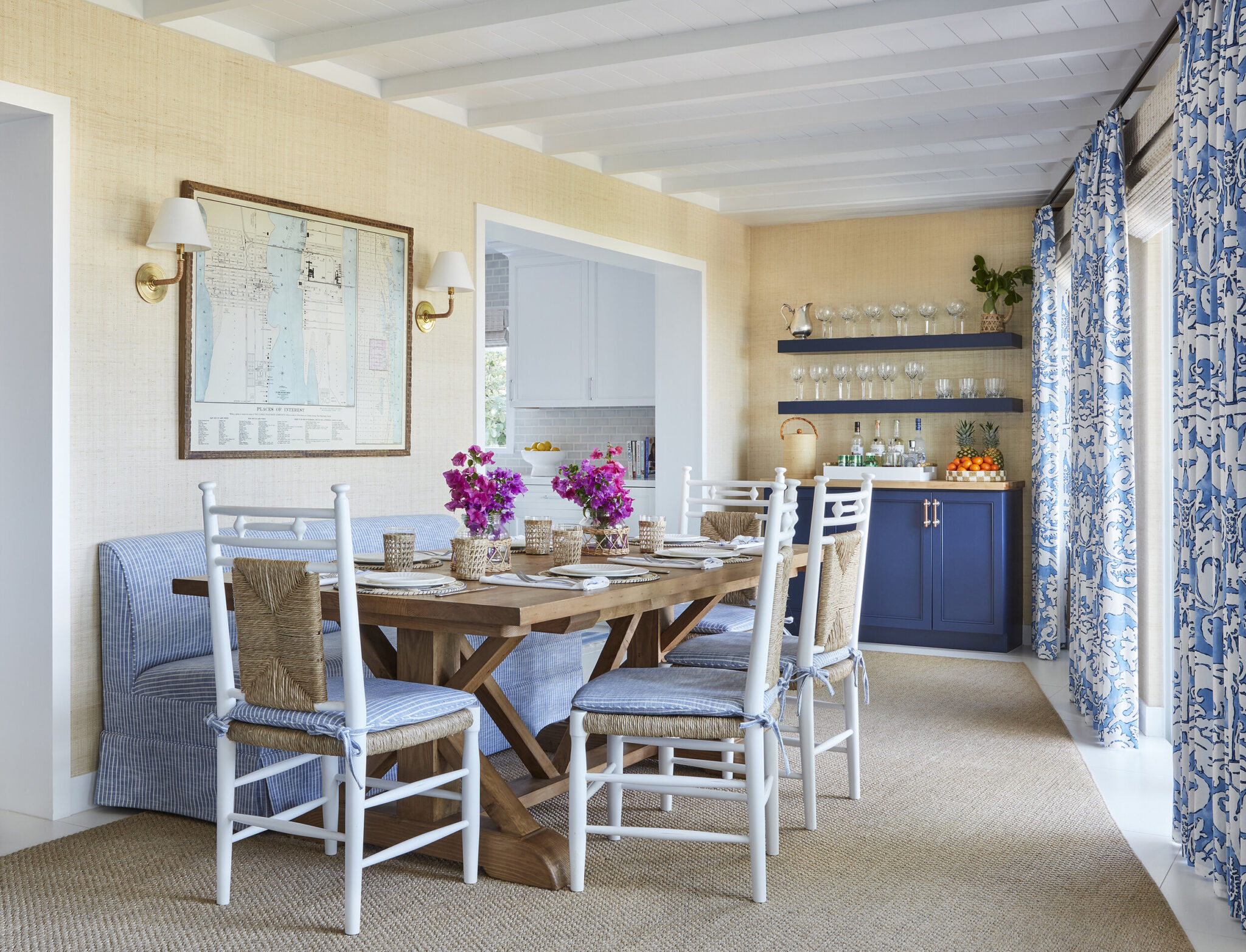 Dining space with white chairs and purple flowers on a table