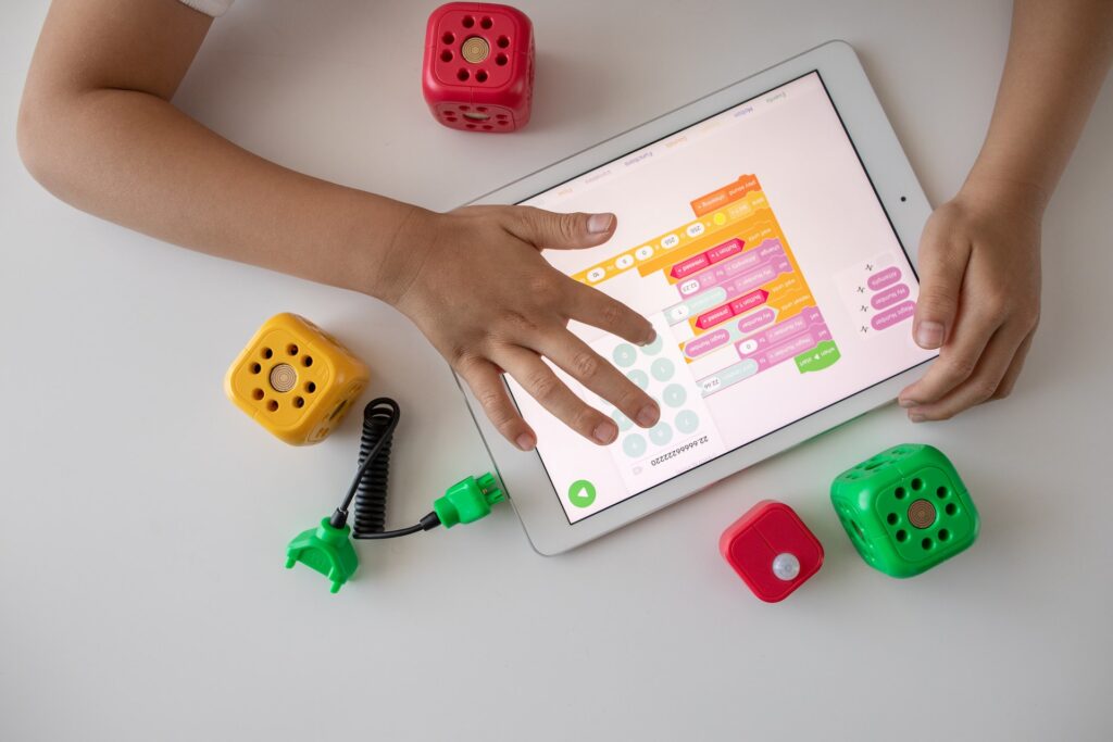 Child learning language on a tablet with toys beside