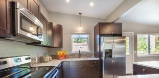 Kitchen with elements, oven, microwave, refrigerator, and kitchen island