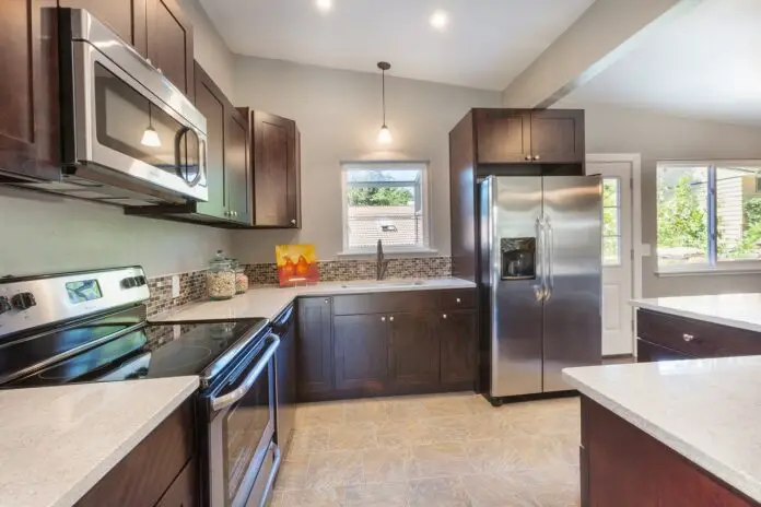 Kitchen with elements, oven, microwave, refrigerator, and kitchen island