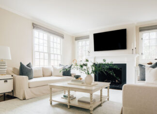 Living room with white coffee table, TV, sofas and a fireplace