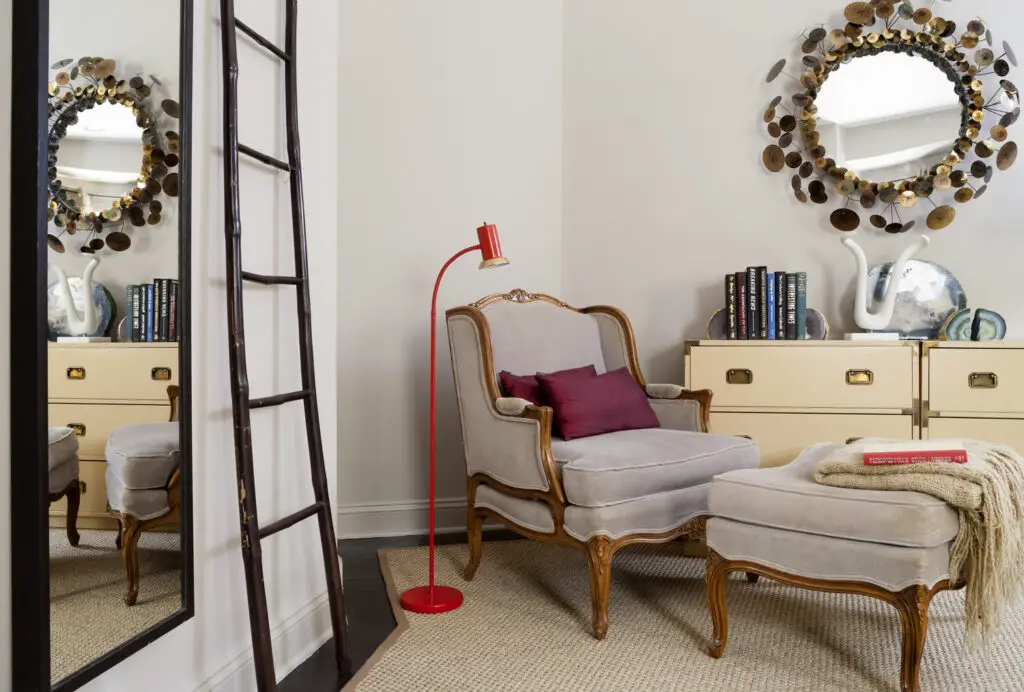 Nook in bedroom with stylish antique armchair and orange floor lamp